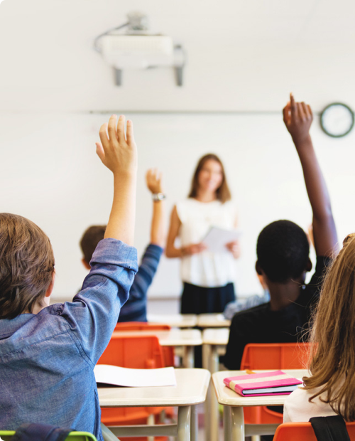 kids in classroom hands up